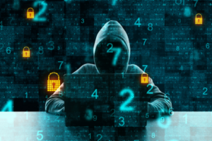 cyber criminal in hoodie in front of a laptop with superimposed numbers and 2 orange padlocks