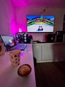 a mince pie and a cup of mulled wine in the front on a table with the Track Mania PS4 game running on the TV in the background at the beat the expert event
